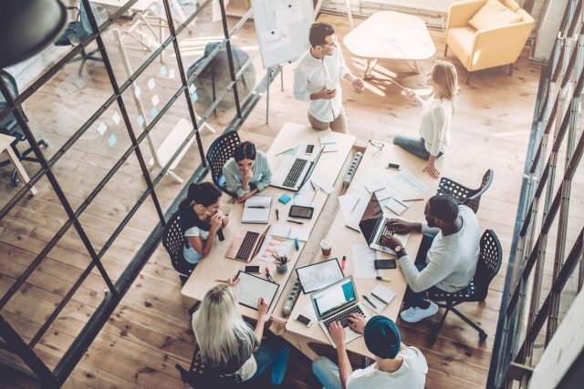 Group of people working at a desk in a conference room