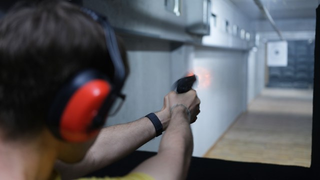 A person shooting a weapon in a gun range showing the infrared flash of the gunshot.